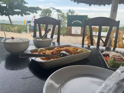 Prato de peixe na telha servido em restaurante à beira-mar em Paripueira, Alagoas, com acompanhamentos de arroz branco e salada fresca.